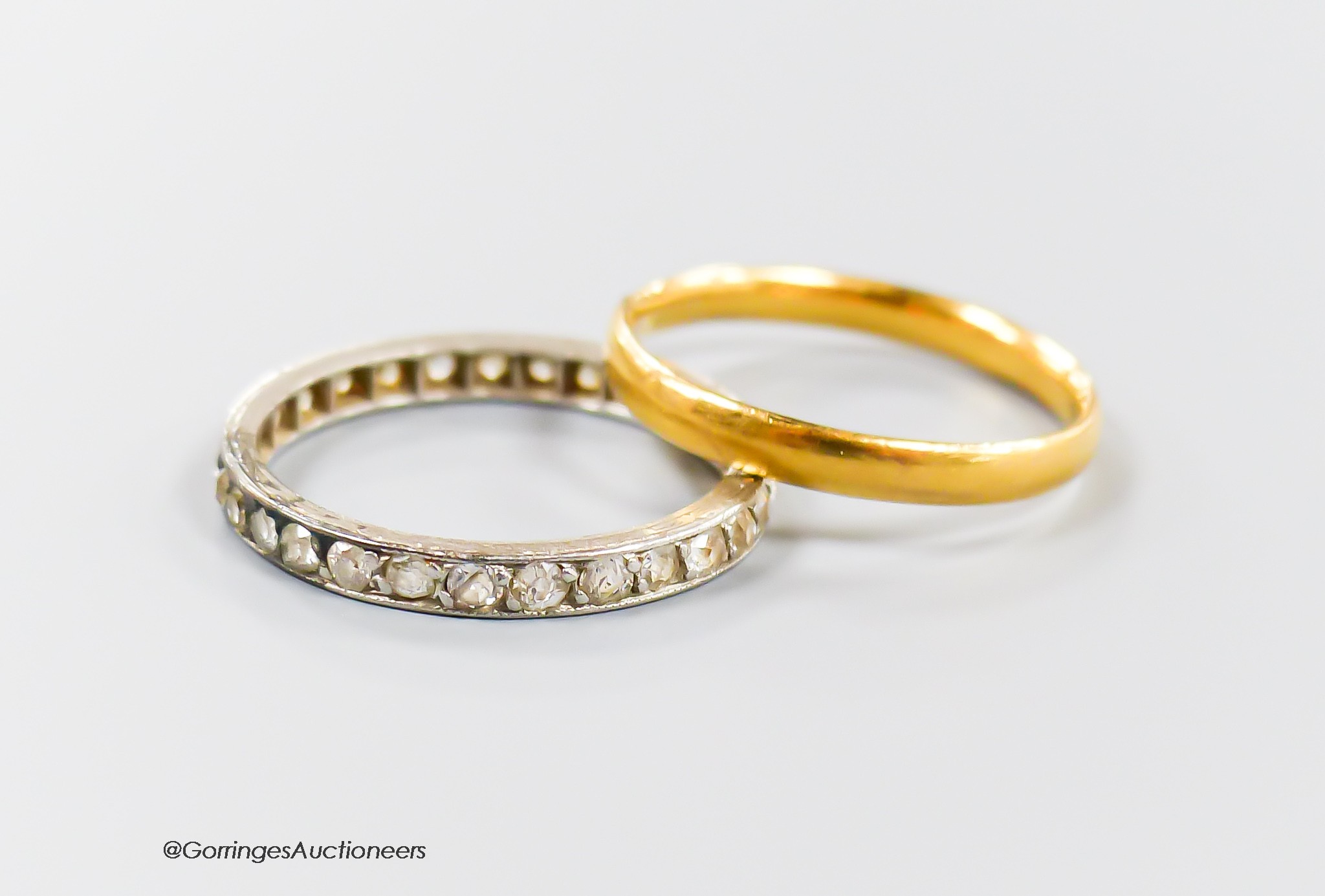 A 22ct gold wedding band, size M, 2.3 grams and a white metal and diamond set full eternity ring, size N, gross 2.5 grams.